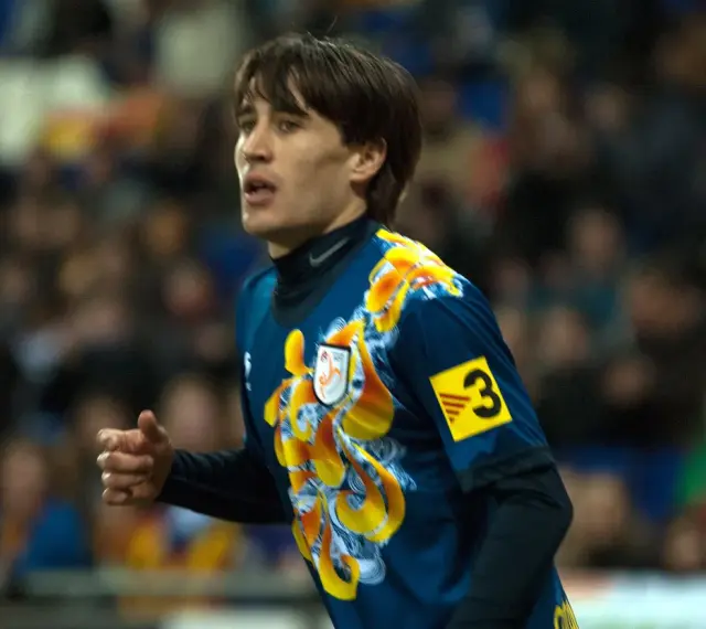 Bojan Krkić w akcji, jego bojan krkić statystyki są imponujące. Piłkarz w niebieskiej koszulce z żółtym wzorem.