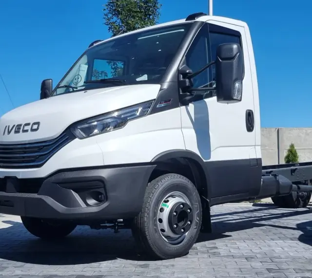Biały Iveco 70C18, podwozie gotowe do zabudowy, stoi na placu z kostki brukowej.