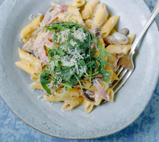 Penne rigate w kremowym sosie z rukolą i parmezanem. Idealne do zatrzymywania sosu, w przeciwieństwie do gładkiego makaronu penne lisce.