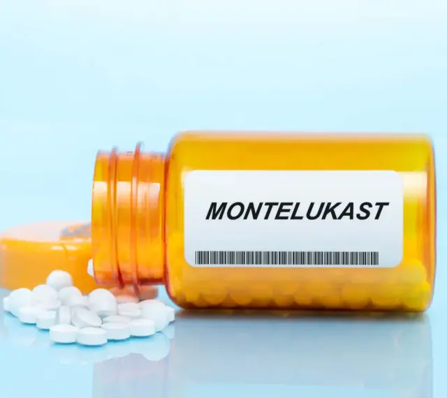 Pomarańczowa buteleczka z lekami, na etykiecie widnieje napis MONTELUKAST. Obok rozsypane białe tabletki.