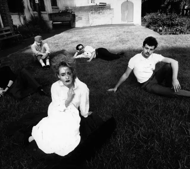Zespół Dead Can Dance na trawie, w tym Lisa Gerrard w białej sukni.