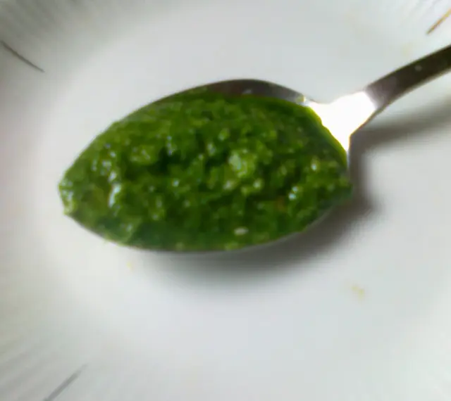 Łyżeczka pełna aromatycznego pesto z pietruszki, gotowa do podania.