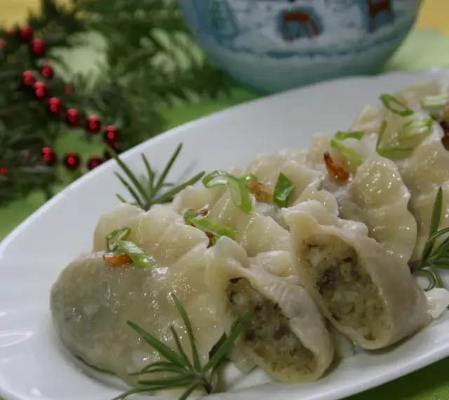 Pyszne pierogi ukraińskie, udekorowane szczypiorkiem i rozmarynem, na świątecznym stole.