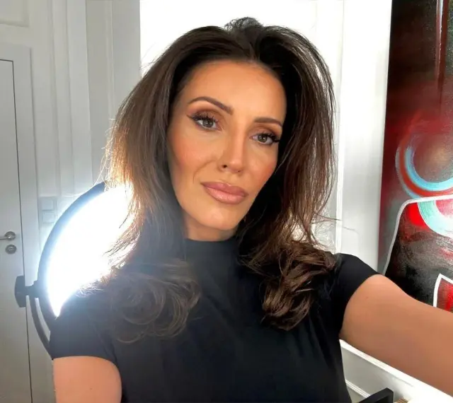 Dominika Serowska, wiek nieznany, pozuje do selfie w czarnej bluzce. W tle widać drzwi, lampę i abstrakcyjny obraz.