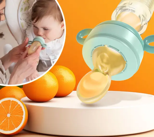 Mama karmi dziecko smoczkiem do owoców, który wygląda jak mały dzbanuszek z pomarańczowym płynem. Obok pomarańcze.