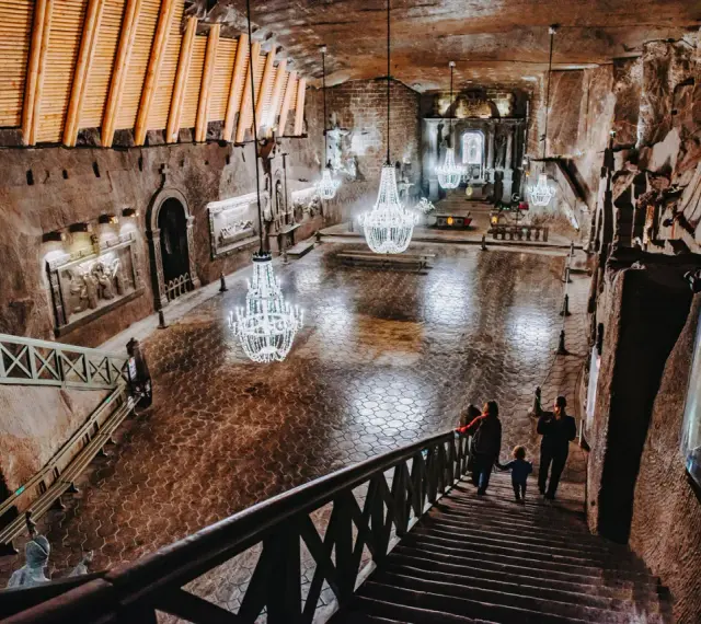 Wielka komora w kopalni soli w Wieliczce, z kryształowymi żyrandolami. Sprawdź kopalnia soli wieliczka cennik, by poznać ceny biletów.