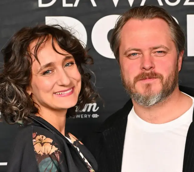Kamila Kuboth Schuchardt uśmiecha się obok mężczyzny z brodą.