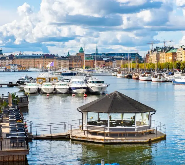 Widok na port w Sztokholmie, z łodziami i budynkami w tle. To jedno z szwecja najpiękniejsze miejsca.