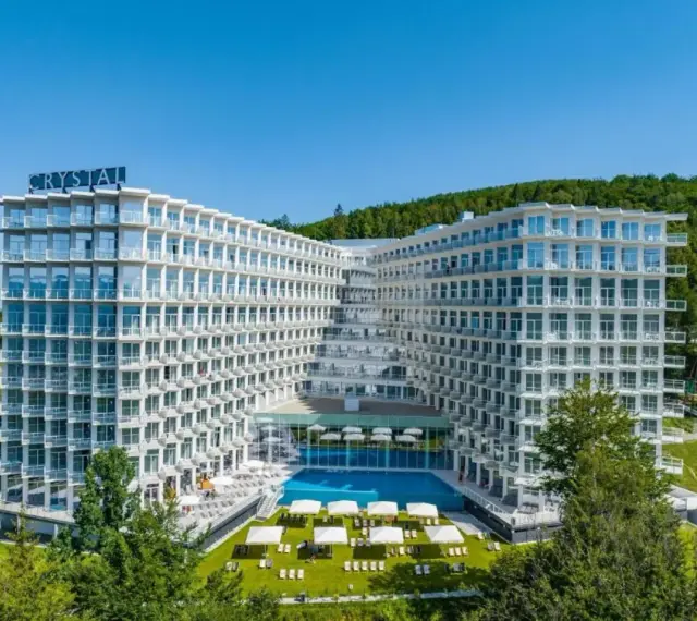Nowoczesny hotel Crystal w Wiśle, z basenem i tarasami, otoczony zielenią. Idealne miejsce na górski relaks w Wiśle Mountain Spa.