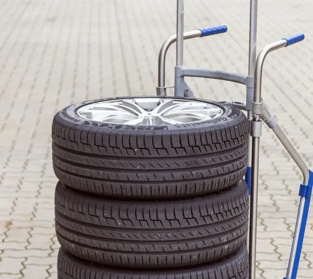 Stos czterech opon samochodowych na wózku. Zastanawiasz się, ile waży opona samochodowa?