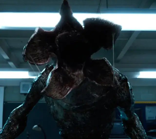Potwór z serialu Stranger Things, Demogorgon, z otwartą paszczą w klasie.