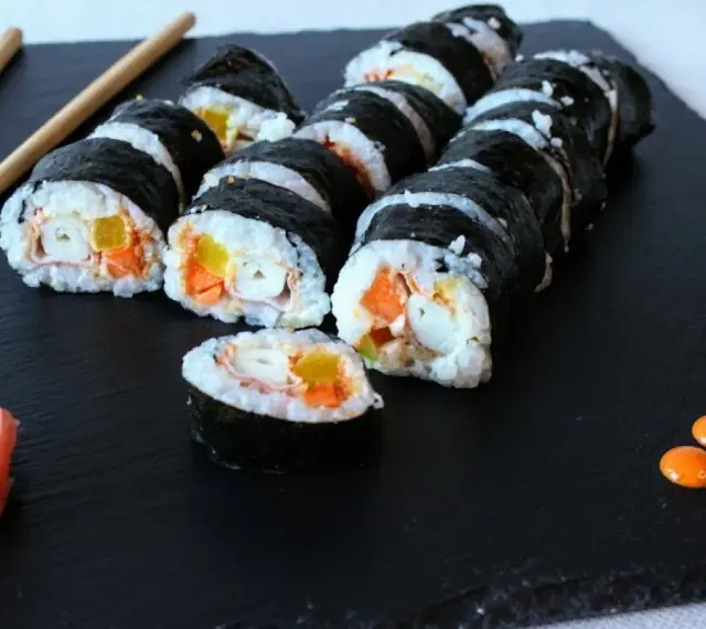 Roladki sushi z paluszkami surimi, marchewką i papryką. Prosty sposób, jak przygotować paluszki surimi do sushi.