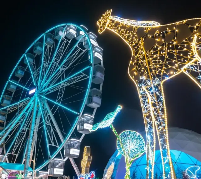 Leuchtende Giraffe und Riesenrad auf einem Jahrmarkt, perfekt für Winterferien Thüringen 2026.