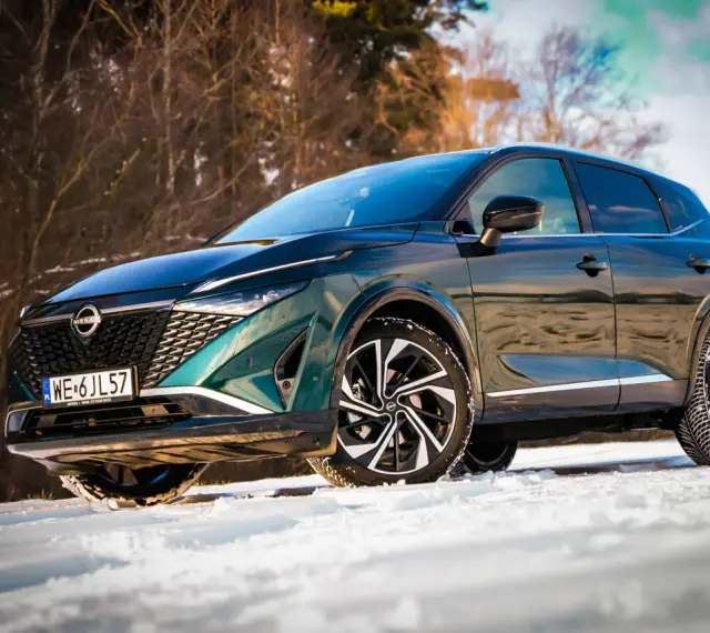 Zielony Nissan Qashqai na śniegu. Wiele osób szuka nissan qashqai opinie, by sprawdzić, jak radzi sobie w trudnych warunkach.