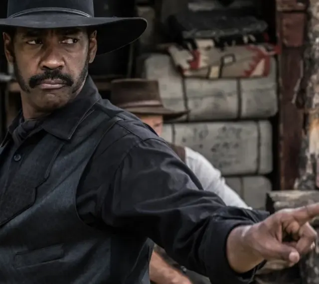 Denzel Washington w westernowym kapeluszu, jak w jego najlepszych filmach, wskazuje palcem.