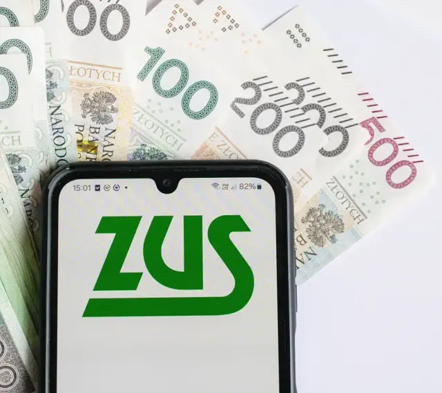 Telefon z logo ZUS na tle polskich banknotów. Oczekujesz zwrotu nadpłaty?