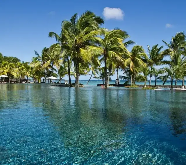 Luksusowy basen z palmami w tle, idealne miejsce na wakacje na Mauritiusie w lutym.