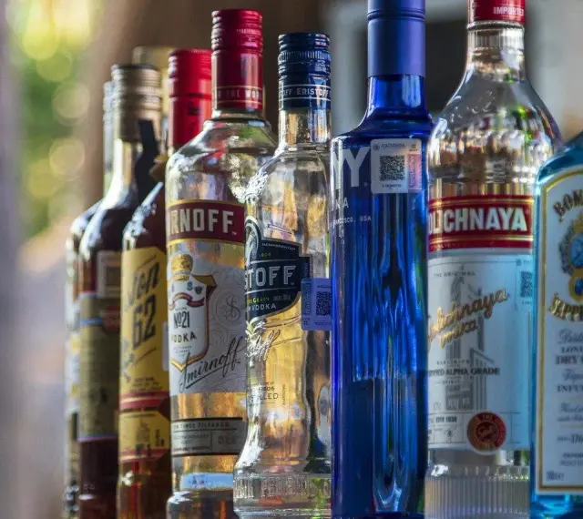 Rząd butelek alkoholu, w tym Smirnoff i Bombay Sapphire, sugeruje ceny alkoholu na Cyprze.