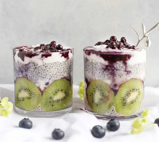 Två glas med chiapudding kvarg, kiwi och blåbär. En härlig frukost eller mellanmål.