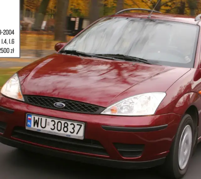 Czerwony Ford Focus Mk1 1.6 benzyna z lat 1998-2004, poruszający się po drodze.