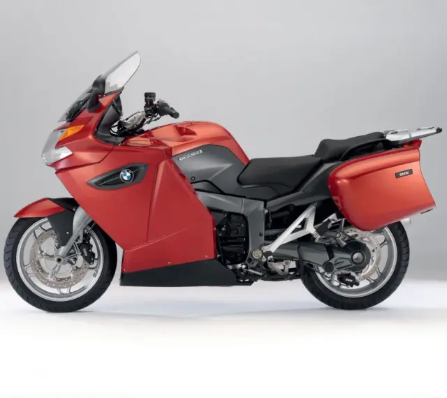 Czerwony motocykl turystyczny BMW K1300GT z kuframi, gotowy na długie podróże.