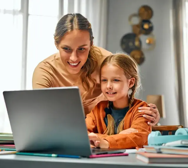 Mama pomaga córce w nauce online. Dni opieki na dziecko mogą być pełne wspólnych chwil przy komputerze.