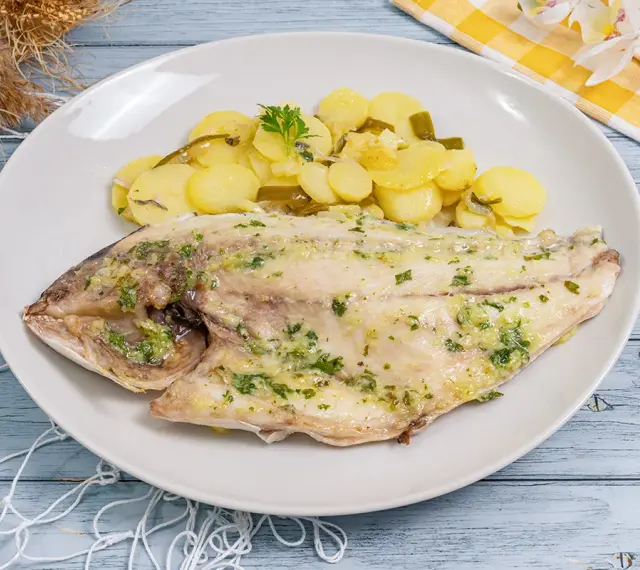 Dorada al horno con patatas panaderas, un plato principal delicioso y saludable.