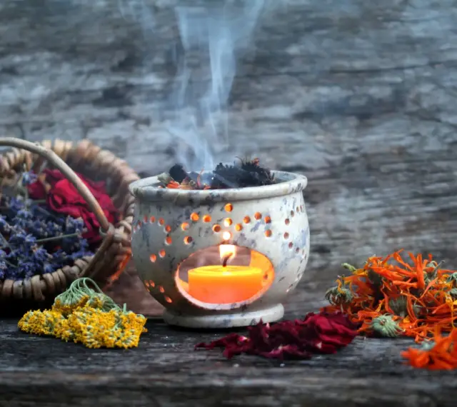 Aromas de lavanda, rosas y caléndula se elevan con el humo de un quemador de incienso, creando un ambiente de limpieza de energías.
