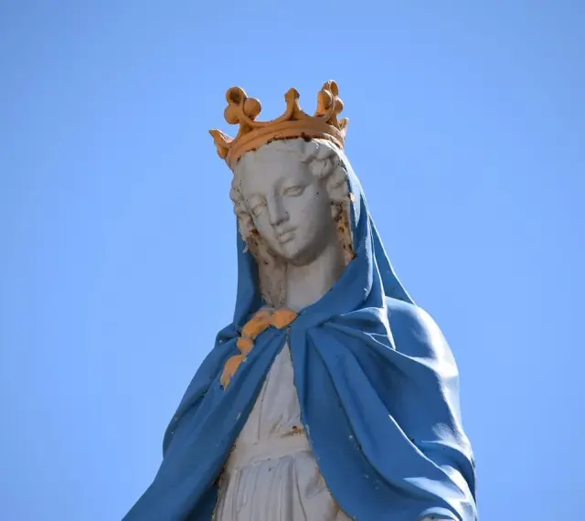 Posąg Matki Bożej z koroną na głowie, spoglądającej w dół. Jak w psalm 121, jej pomoc przychodzi z nieba.