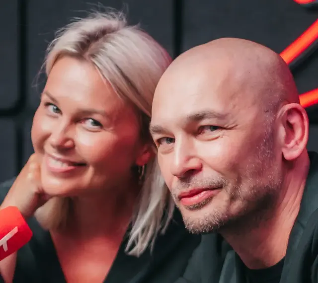 Tomasz Wygoda z żoną i dziećmi, uśmiechnięci przed mikrofonem.