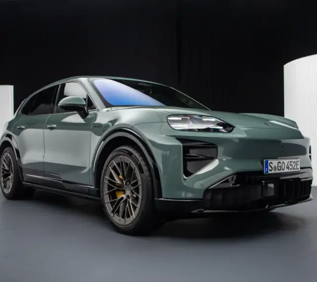 Zielony elektryczny Porsche Macan na ciemnym tle.