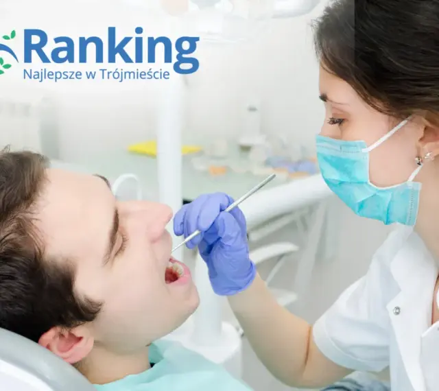 Dentystka w masce bada zęby pacjenta narzędziem stomatologicznym.