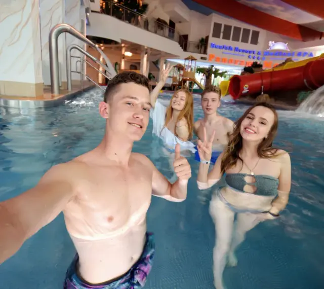 Grupa młodych ludzi cieszy się wodnym szaleństwem w aquaparku. Czy wiek ma znaczenie, by wynająć hotel i spędzić tu czas?