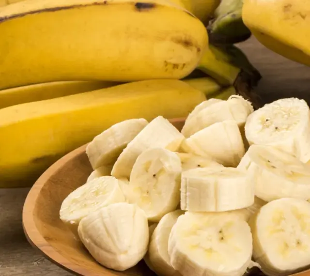 Kawałki banana na drewnianej desce. Banan wartości odżywcze to potas i witaminy.
