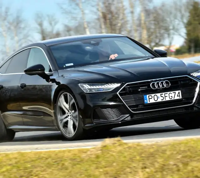 Czarny Audi A7 na drodze. Sprawdź aktualną audi a7 cena i możliwości tego sportowego sedana.