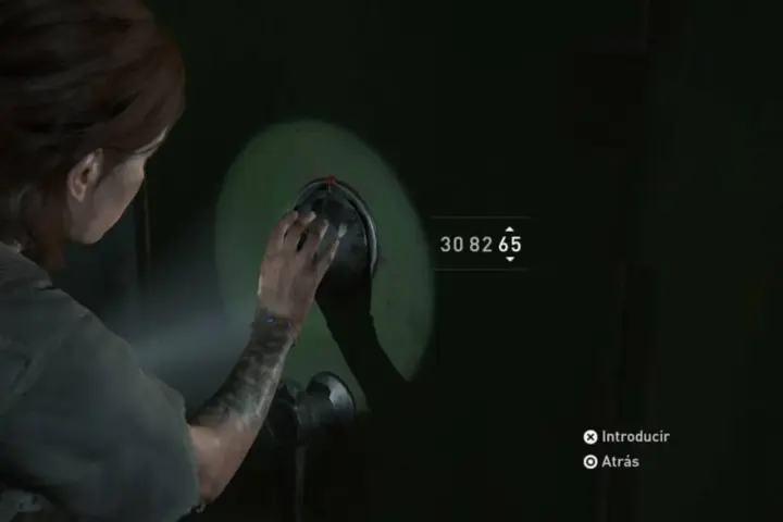 Ellie intenta abrir una de las **cajas fuertes** de The Last of Us 2. El código es 30 82 65.