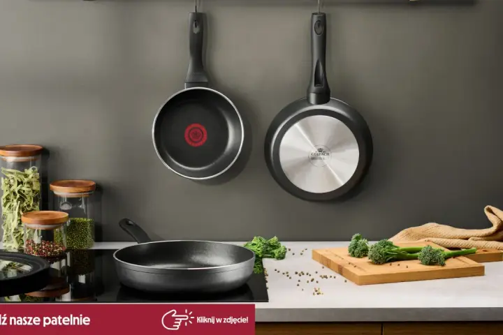 Dwie patelnie wiszące, jedna z logo Tefal, druga Gerlach. Na blacie patelnia, słoiki z makaronem i przyprawami, deska z brokułami. Czy patelnie Tefal można myć w zmywarce? Sprawdź!
