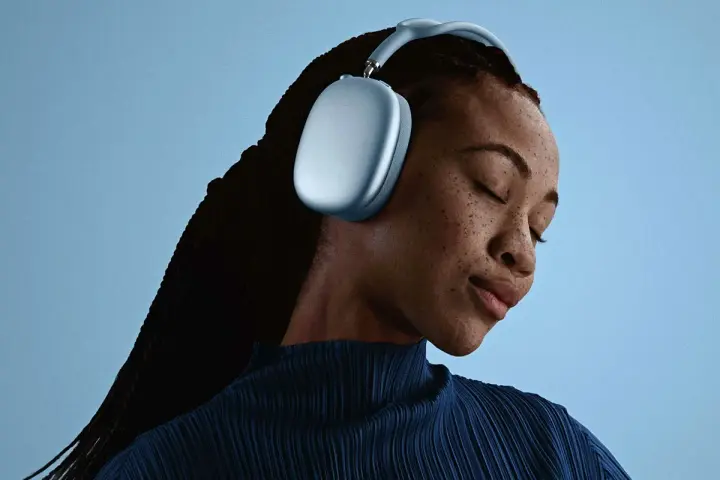 En kvinna med slutna ögon njuter av ljudet från sina ljusblå AirPods Pro Max 2.