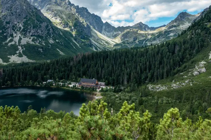 Popradzki Staw z hotelem i górami w tle.