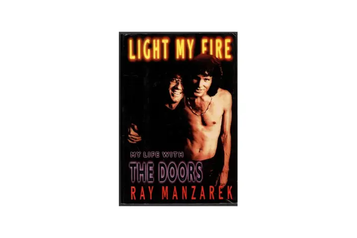 Okładka książki "My Life with The Doors" Raya Manzarka. Neonowy napis "LIGHT MY FIRE" nad dwoma mężczyznami.