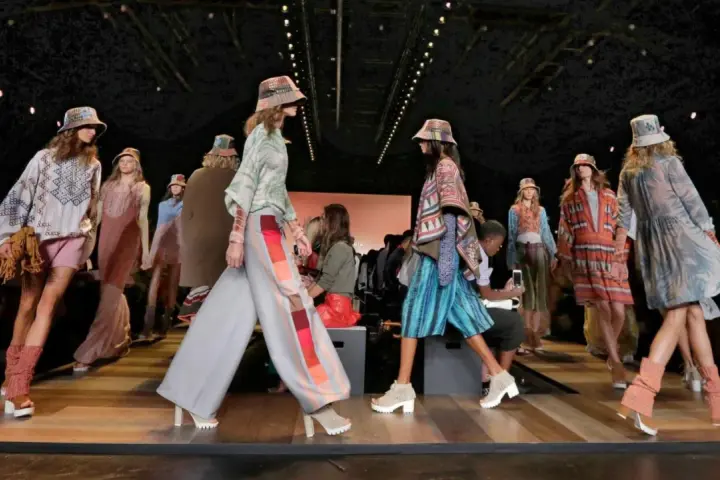 Pokaz mody BCBGMAXAZRIA. Modelki prezentują kolorowe, etniczne stroje i kapelusze na wybiegu.