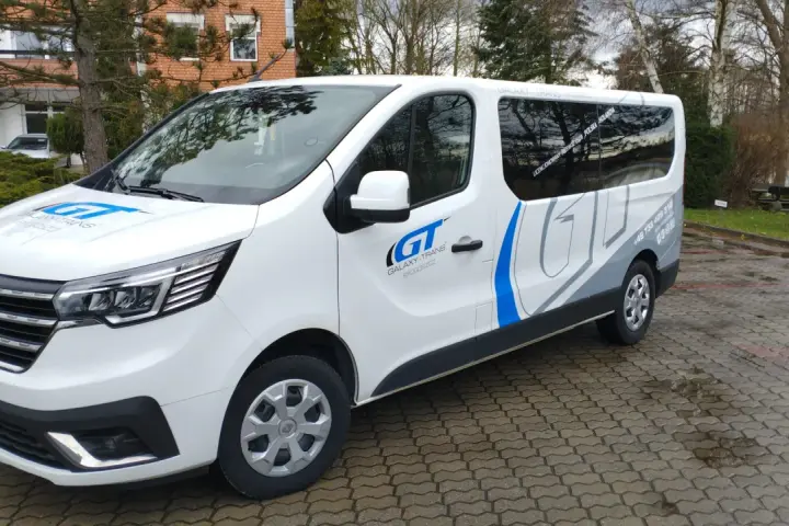 Biały bus Galaxy-Trans z logo GT. Zapytaj, ile kosztuje bus do Holandii, by poznać ceny przejazdów.