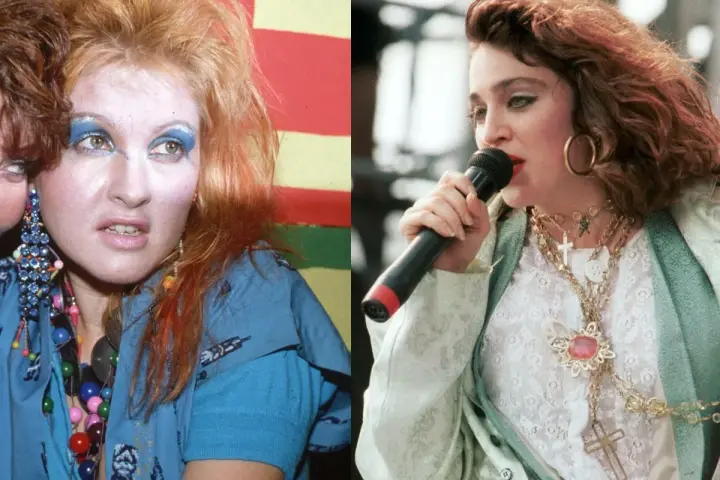 Ikony lat 80. w ekstrawaganckich stylizacjach na imprezę: Cyndi Lauper z kolorowym makijażem i Madonna z krzyżykami na szyi.