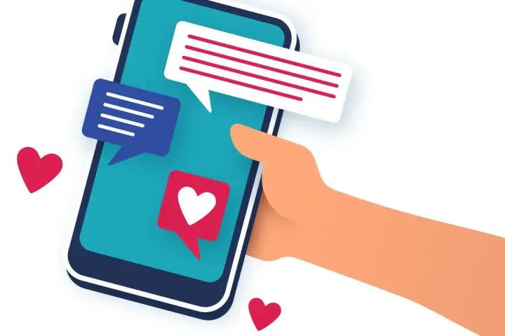 Main tenant une main un smartphone avec des bulles de discussion et des cœurs. L'image évoque le sentiment d'attente et d'espoir après le premier rendez vous.