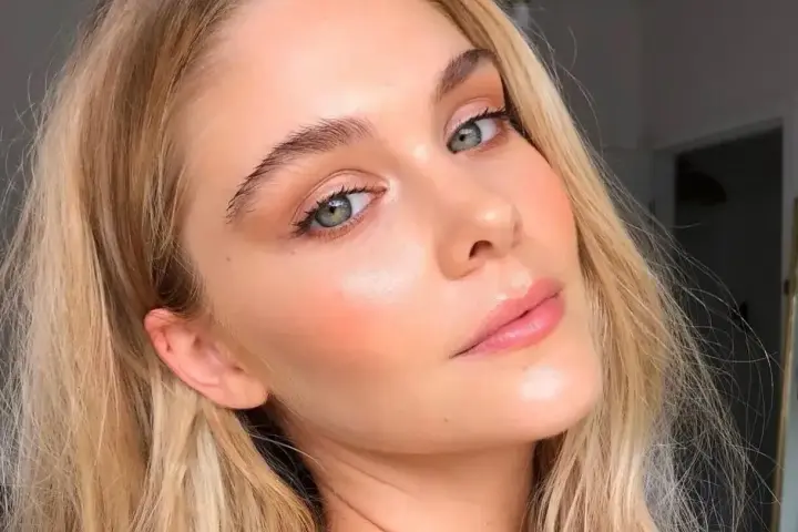 Delikatny makijaż typu "makeup no makeup" podkreśla naturalne piękno kobiety z zielonymi oczami i blond włosami.