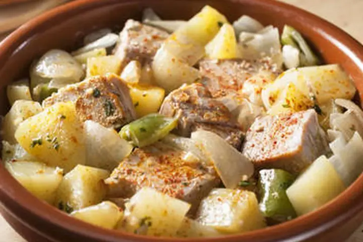 Un delicioso marmitako de atún con patatas, pimientos y cebolla en una cazuela de barro.