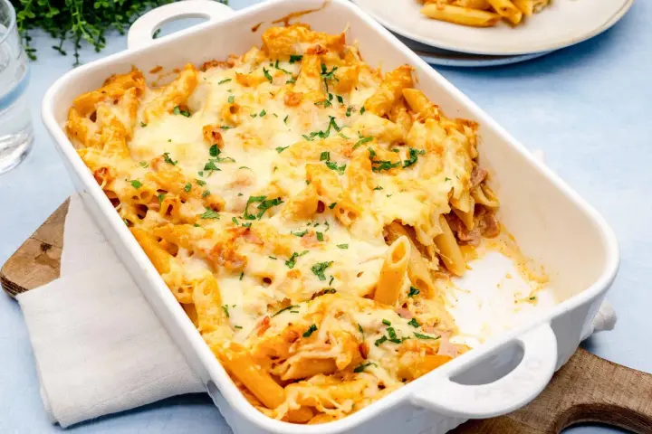 Herzhaftes Nudel Schinken Gratin mit geschmolzenem Käse und Petersilie, bereit zum Servieren.