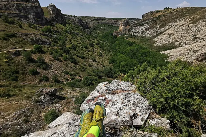 Botas de trail running sobre roca, contemplando el cañón del río Dulce en Guadalajara.