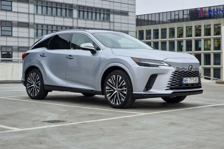 Eleganckie japońskie auta, jak ten srebrny Lexus, prezentują się nowocześnie na tle biurowców.