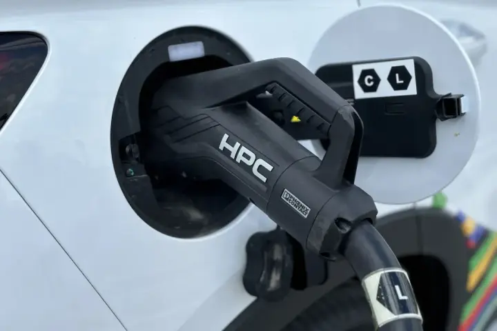 Ładowanie samochodu elektrycznego. Wtyczka HPC podłączona do portu ładowania, zapewniająca przepływ napięcia.